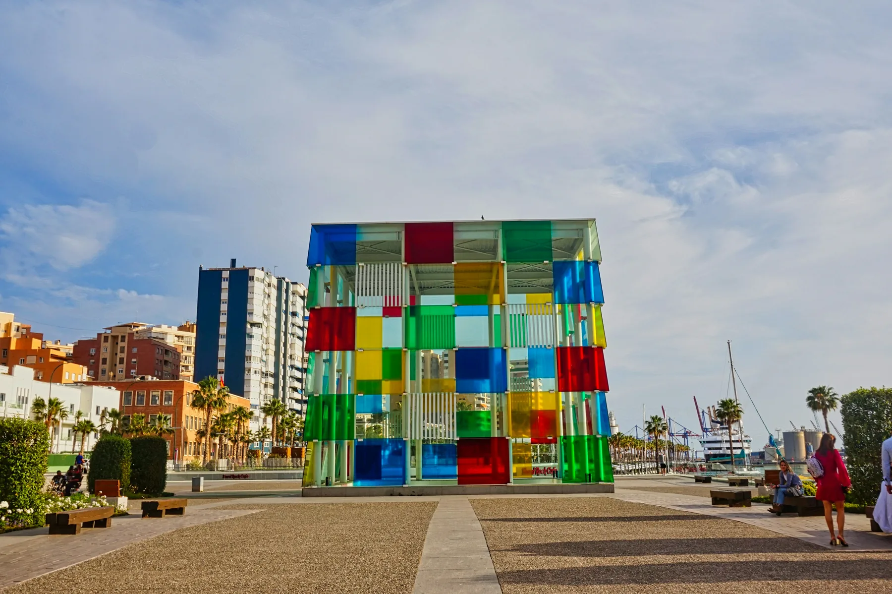 Barevná skleněná kostka Centre Pompidou Málaga na nábřeží přístavu pod zamračenou oblohou